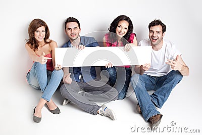 Happy friends showing white banner Stock Photo