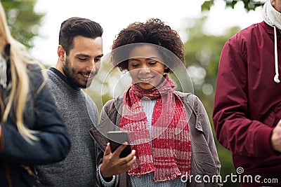 Happy friends with smartphone outdoors Stock Photo