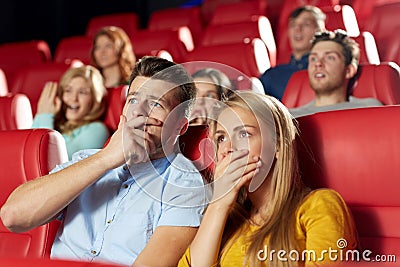 Happy friends watching horror movie in theater Stock Photo