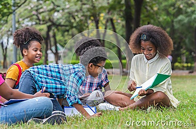 Group of African American children practice drawing in a book and sitting in the park. Education outdoor concept Stock Photo