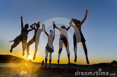 Happy funny people jumping in the sunset Stock Photo