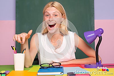 Happy funny teacher winking. Female student. Young teacher or tutor at classroom in school. Woman education. Good idea. Stock Photo