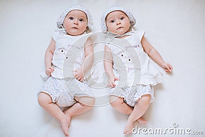 Happy funny twin sisters girls playing at home on a white carpet background. The concept of a happy childhood Stock Photo