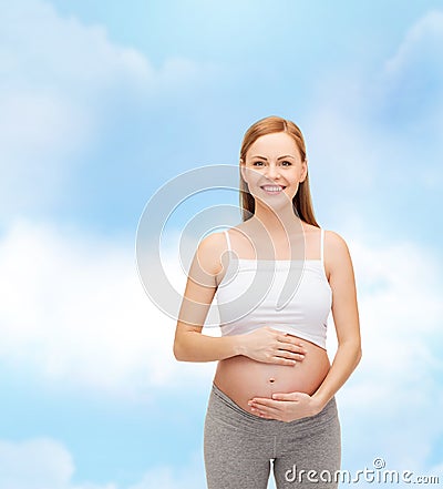 Happy future mother touching her belly Stock Photo