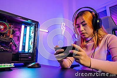 Happy Gamer playing video game online with smartphone with neon lights Stock Photo