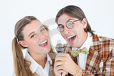 Happy geeky hipsters singing with microphone Stock Photo