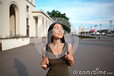happy girl with a backpack walks around the city Stock Photo