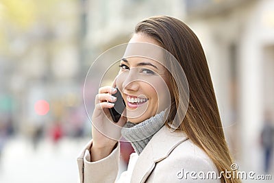 Happy girl calling on phone in winter and looking you Stock Photo