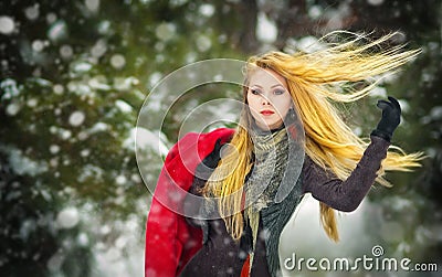Happy girl with cap and gloves playing with snow in the winter landscape Stock Photo