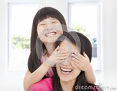 Happy girl cover her mother eyes Stock Photo