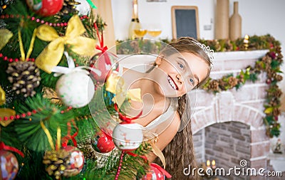 Happy girl decorates Christmas tree. Stock Photo