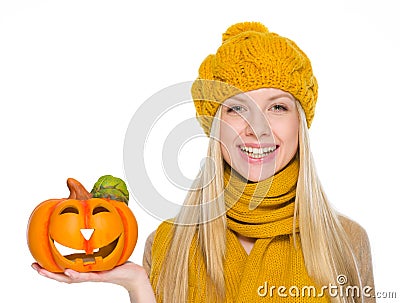 Happy girl in hat and scarf holding jack-o-lantern Stock Photo