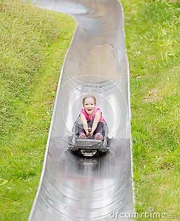 Happy girl having fun at summer bobsled track Stock Photo