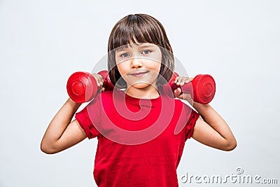 Happy girl lifting dumbbells for girl-boy fairness at sport Stock Photo