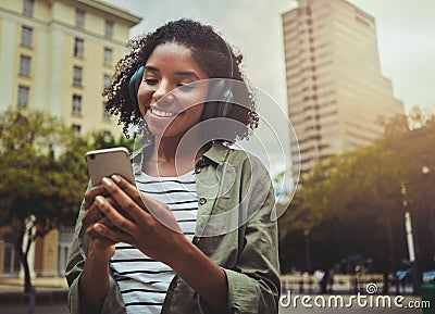 Happy girl listening to music browsing smart phone content Stock Photo