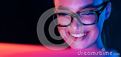 Happy girl looking at laptop screen at night Stock Photo