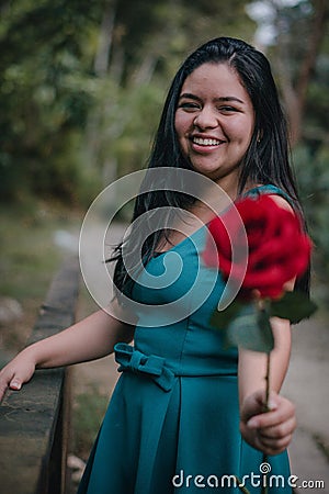 Happy girl in the middle of a bridge with rose in hands Stock Photo