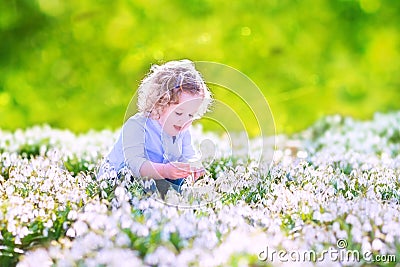 Happy girl playing with first spring flowers Stock Photo