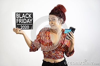 Happy girl raising her hands and shoulders in show of resignation and conformity with a credit card and cell phone in one hand and Stock Photo