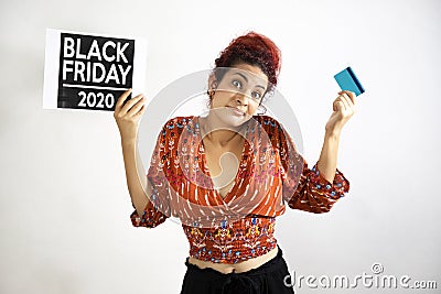 Happy girl raising her hands and shoulders in show of resignation and conformity with a credit card in one hand and the other a Stock Photo