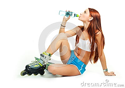 Happy girl with rollerskates drinking water Stock Photo