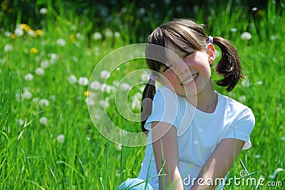 Happy girl sat in field Stock Photo