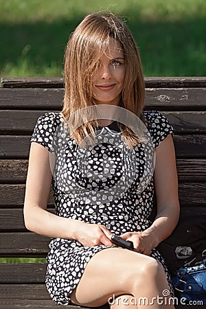 Happy girl sitting on a bench Stock Photo