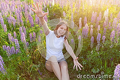 Happy girl smiling outdoor. Beautiful young brunete woman resting on summer field with blooming wild flowers green Stock Photo