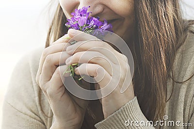 Happy woman sniffs a small bouquet of flowers, springtime Stock Photo