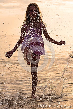 Happy girl splashing water during summer holidays Stock Photo