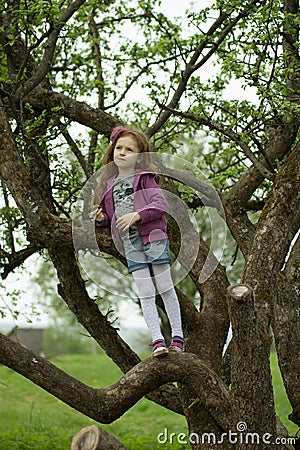 Happy girl standing on branch huge tree Stock Photo