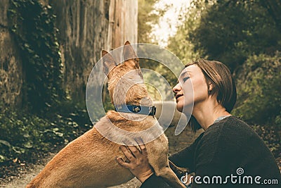 Happy girl stroking and kissing her dog Stock Photo