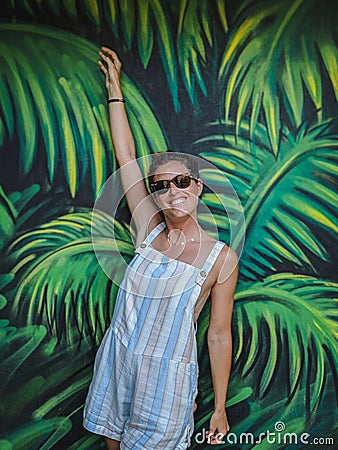 Happy girl in a tropical wall graffiti Editorial Stock Photo