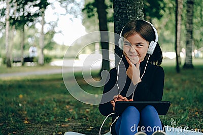 Happy girl using digital tablet in the park Stock Photo