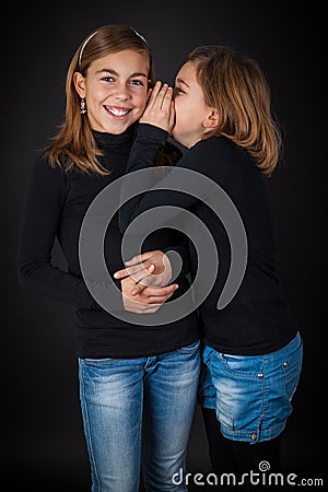 Happy girlfriends whispering Stock Photo