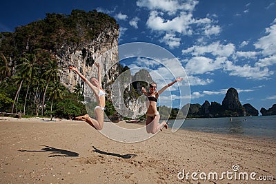 Happy girls jump at beautiful seashore Stock Photo