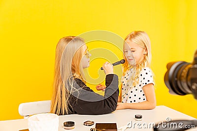 Happy girls sisters at home in front of camera making vlog. working as blogger, recording video tutorial for Internet. Stock Photo