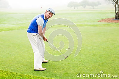 Happy golfer cheering on putting green Stock Photo