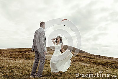 happy gorgeous bride running to groom and having fun, luxury ceremony at mountains with amazing view, space for Stock Photo