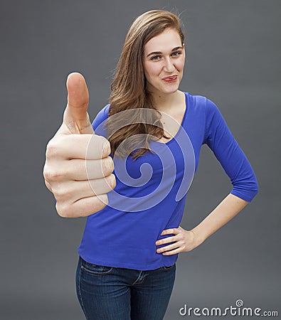 Happy gorgeous young woman agreeing with a large thumbs up Stock Photo