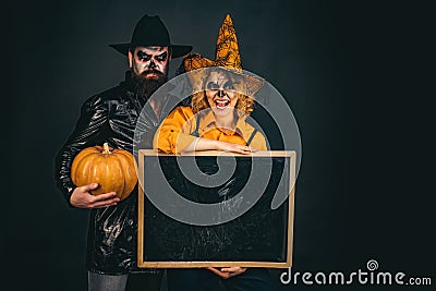 Happy gothic couple in Halloween costume. Jack-o-lanterns. Halloween poster or greeting card - people concept. Stock Photo