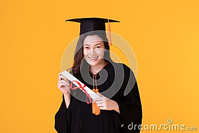 Happy Graduate asian woman in cap and gowm holding Certificated Stock Photo