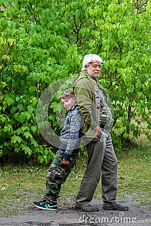 Happy senior and boy in green park Stock Photo