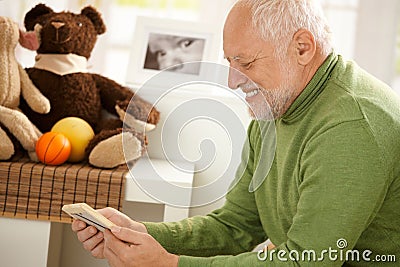 Happy grandfather looking at photo Stock Photo