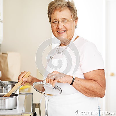 Happy grandmother cooking in kitchen Stock Photo