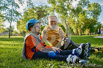 Happy grandpa and grandchild eating ice-cream after roller skating Stock Photo