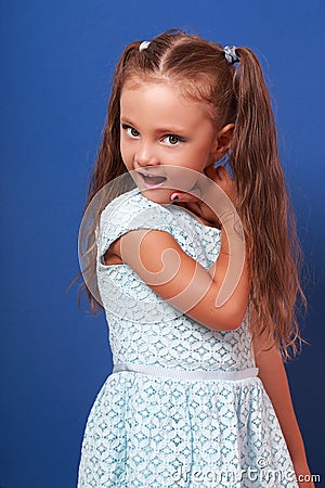 Happy grimacing kid girl posing in blue fashion dress. Closeup p Stock Photo