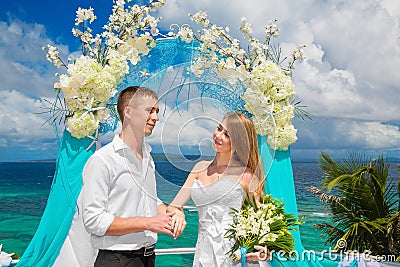 Happy groom and bride with wedding rings under the arch decorate Stock Photo