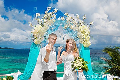 Happy groom and bride with wedding rings under the arch decorate Stock Photo