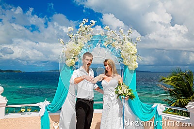 Happy groom and bride with wedding rings under the arch decorate Stock Photo